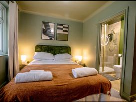 A bedroom with a bed and attached bathroom at 2 Bedroom Apartment Sleeps 3 - Garden - Pets in Carbis Bay