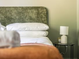 A bedroom with a green headboard and a bedside table at 2 Bedroom Apartment Sleeps 3 Garden Pets in Carbis Bay