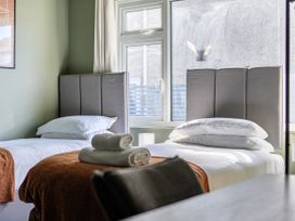 A bedroom with two beds and a window at 2 Bedroom Apartment Sleeps 3 Garden Pets Carbis Bay
