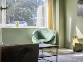 A living room with an armchair and coffee table at 2 Bedroom Apartment Sleeps 3 Garden Pets in Carbis Bay