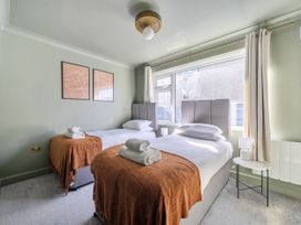 A bedroom with two beds and a bedside table at 2 Bedroom Apartment Sleeps 3 Garden Pets in Carbis Bay
