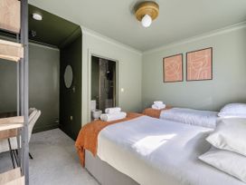 A bedroom with two beds, desk, and bathroom access at 2 Bedroom Apartment Sleeps 3 Garden Pets in Carbis Bay