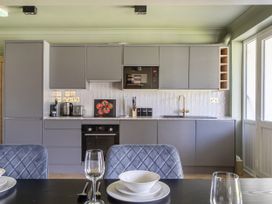 A kitchen with cabinets, oven, microwave and sink at 2 Bedroom Apartment Sleeps 3 Garden Pets Carbis Bay