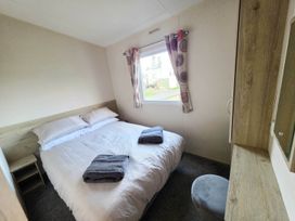 A bedroom with a bed and a window at Static Caravan 3 Bed Sleeps 8 Dog Friendly Parking Northampton