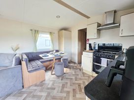 A kitchen with a dining area and appliances at Static Caravan 3 Bed Sleeps 8 Dog Friendly Parking Northampton