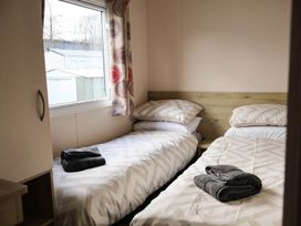 A bedroom with two beds and a window at Static Caravan 3 Bed Sleeps 8 Dog Friendly Parking Northampton