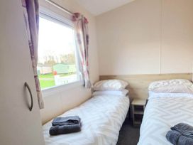 A bedroom with two single beds and a window at Static Caravan 3 Bed Sleeps 8 Dog Friendly Parking Northampton