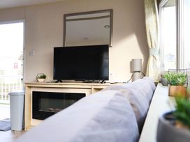 A living room with a television and plants at Static Caravan 3 Bed Sleeps 8 Dog Friendly Parking Northampton