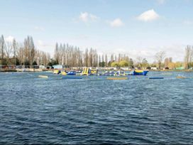 An inflatable obstacle course on water with trailers and trees in the background at Static Caravan 3 Bed Sleeps 8 Dog Friendly Parking Northampton