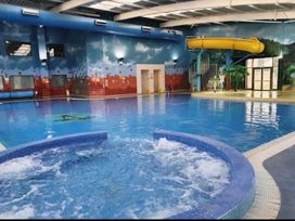 An indoor pool with a water slide and jacuzzi at Static Caravan 3 Bed Sleeps 8 Dog Friendly Parking Northampton