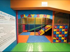 A play area with a slide and colored foam blocks at the play zone