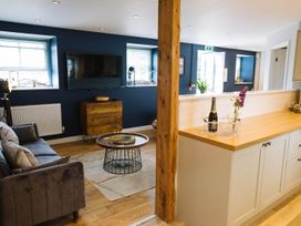 A living room with a sofa and television at Snowdon Studio Apartment Tal-y-cafn near Llandudno Junction