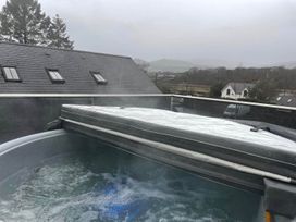 A hot tub with cover and steam in an outdoor area at Snowdon Studio Apartment in Tal-y-cafn near Llandudno Junction