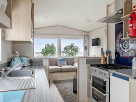 A kitchen with a stove and sink at Cabin - Sleeps 4 - Pets Ok - Balcony - Parking, Haven Park, Doniford Bay near Watchet