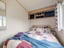 A bedroom with a bed and shelves at Cabin - Sleeps 4 - Pets Ok - Balcony - Parking, Haven Park, Doniford Bay near Watchet