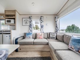 A living room with a sofa and coffee table at Cabin - Sleeps 4 - Pets Ok - Balcony - Parking, Haven Park, Doniford Bay near Watchet
