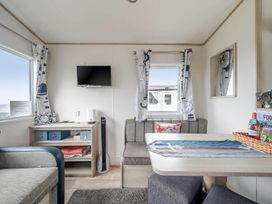 A living room with a tv and sofa at Cabin - Sleeps 4 - Pets Ok - Balcony - Parking Haven Park, Doniford Bay near Watchet