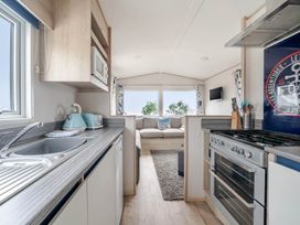 A kitchen with appliances and a couch at Cabin - Sleeps 4 - Pets Ok - Balcony - Parking in Haven Park, Doniford Bay near Watchet