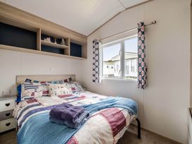 A bedroom with a bed and shelf at Cabin - Sleeps 4 - Pets Ok - Balcony - Parking, Haven Park, Doniford Bay near Watchet