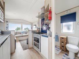 A kitchen with appliances and seating area at Cabin - Sleeps 4 - Pets Ok - Balcony - Parking in Haven Park, Doniford Bay near Watchet
