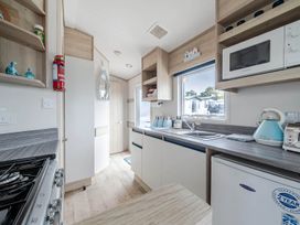 A kitchen with various appliances and storage at Cabin - Sleeps 4 - Pets Ok - Balcony - Parking Haven Park, Doniford Bay near Watchet