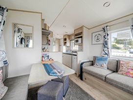 A living room with a kitchen unit and sofa at Cabin - Sleeps 4 - Pets Ok - Balcony - Parking Haven Park, Doniford Bay near Watchet