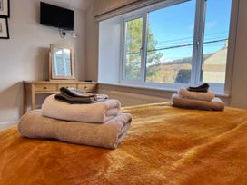 A bedroom with towels, a mirror, and a television at Cottage Sleeps 6 Garden Parking Beaulieu Farm near Coleford