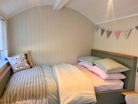 A bedroom with a bed and decorative bunting at Peaceful Shepherd Hut near Clovelly