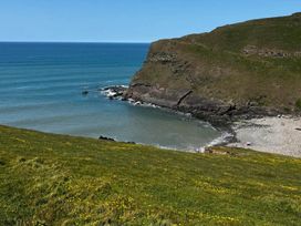 A beach view with cliffs and ocean water at Peaceful Shepherd Hut near Clovelly Buckland Brewer near Great Torrington