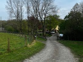 A gravel path leading to a house with trees in the surroundings at Peaceful Shepherd Hut near Clovelly Buckland Brewer near Great Torrington