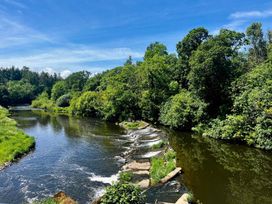 A river with trees and a waterfall at Peaceful Shepherd Hut near Clovelly