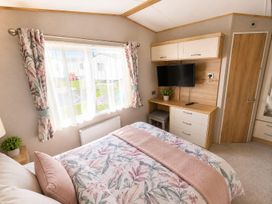 A bedroom with a bed and tv at Cala Gran 3Bed Caravan Sleeps 8 Wrap Decking in Fleetwood