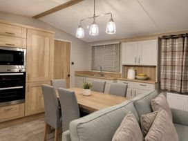 A kitchen with a dining table and appliances at Cala Gran 3Bed Caravan Sleeps 8 Wrap Decking Fleetwood