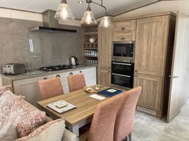 A kitchen with a dining area and modern appliances at The Old Barn in Manchester