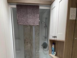 A bathroom with a shower cubicle and cabinet at The Old Barn in Manchester