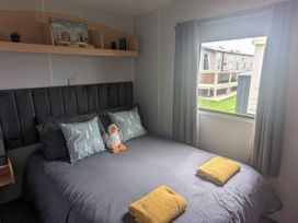 A bedroom with a bed and stuffed animal at The Old Barn in Anderby Creek