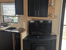 A kitchen with a sink and television at 