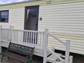 An exterior view of a caravan with steps and a bench at 
