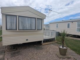 A static caravan with a balcony at a holiday park in Anderby Creek