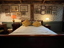 A bedroom with a bed and desk at The Old Barn in Bovey Tracey