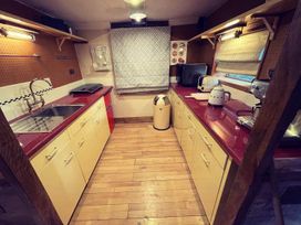 A kitchen with sink and appliances at The Old Barn in Bovey Tracey