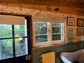 A bathroom with a window and bathtub at The Old Barn in Bovey Tracey