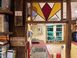 A kitchen with a stained glass window and sink at The Old Barn in Bovey Tracey