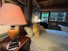 A bedroom with a bed and lamp at The Old Barn in Bovey Tracey