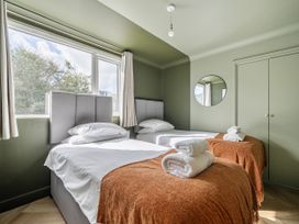 A bedroom with two beds and a mirror at 1 Bedroom Apartment, sleeping 3 with balcony and pet friendly, Carbis Bay