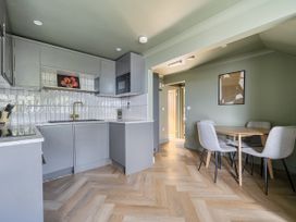 A kitchen with table and chairs at 1 Bedroom Apartment, sleeping 3 with balcony and pet friendly in Carbis Bay