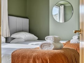 A bedroom with a bed and towels at 1 Bedroom Apartment, sleeping 3 with balcony and pet friendly, Carbis Bay