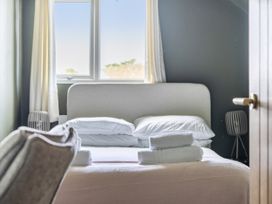 A bedroom with bed and towels at 1 Bedroom Apartment, sleeping 3 with balcony and pet friendly, Carbis Bay