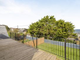 An outdoor area with decking and railing overlooking grass and a tree at 1 Bedroom Apartment, sleeping 3 with balcony and pet friendly, Carbis Bay