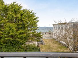 A view of the ocean from a balcony with a tree and buildings at 1 Bedroom Apartment, sleeping 3 with balcony and pet friendly, Carbis Bay